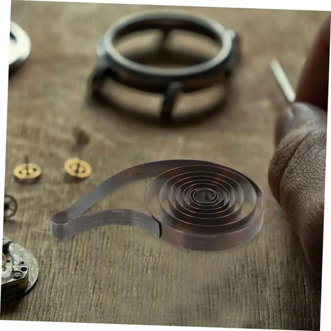 4 Pack Steel Clock Main Springs For Mechanical Clocks Replacement Parts on wooden table with tools in background