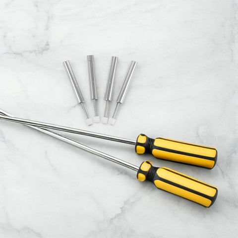 Two yellow-handled magnetic screwdrivers with four interchangeable bits on marble surface