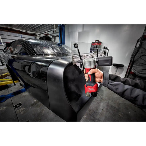 Milwaukee M12 Cordless Rivet Tool Bare Unit in use, fastening rivets on a black car body, showcasing compact design.