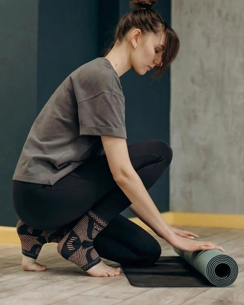 Woman wearing Copper Infused Ankle Brace Compression Sleeve for Men and Women Foot Pain Relief Sprain Recovery during yoga.