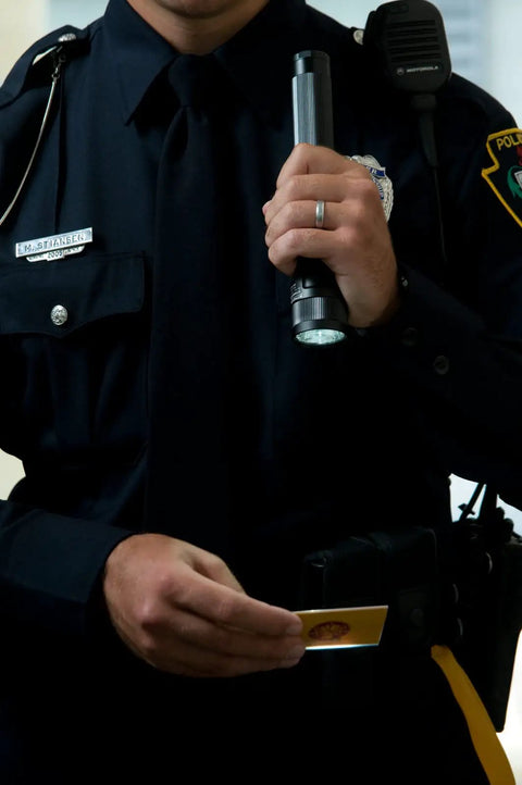 Security personnel holding Stinger DS 425-Lumen Rechargeable LED Flashlight with Dual Switches and DC Steady Charger.