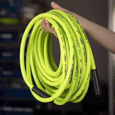 Person holding All Weather 1/2 Inch By 50 Ft Hybrid Air Hose With 1/2 Inch MNPT Fittings, ZillaGreen, coiled and lightweight.