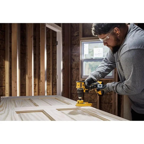 Person using No Fuss Hella Slick 20V Max Brushless Cordless Drill Driver Kit With Compact Atomic Frame on a wooden door.