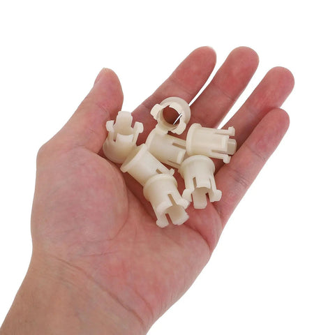 Thirty Piece White Plastic Furniture Caster Socket Inserts in hand for rolling chair repairs.