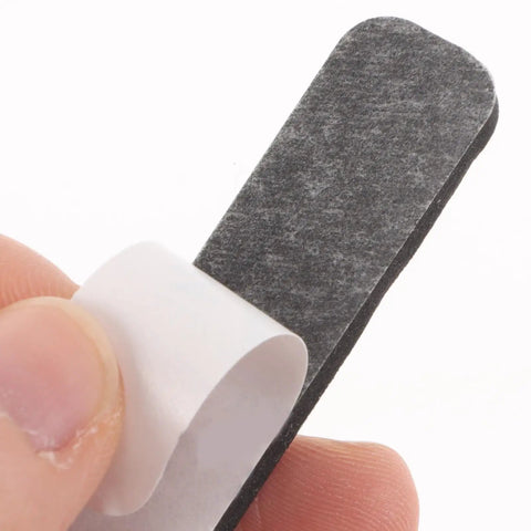 Hand holding a black foam cushion from the Set Of Four Premium Keyboard Soundproof Foam Space Bar Acoustic Cushion.
