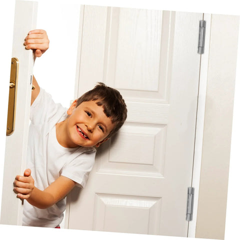 Smiling child peeking through a door with self-closing door hinge shown.