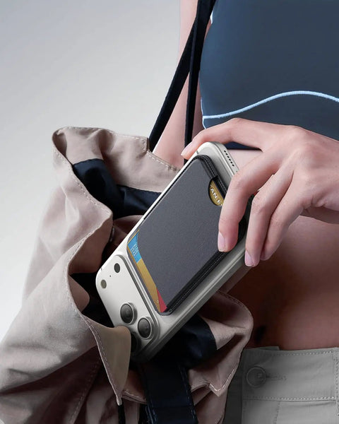 Person placing iPhone with MagSafe Wallet With Five Card Slots And Stand into bag, showing RFID Blocking Vegan Leather, Black.