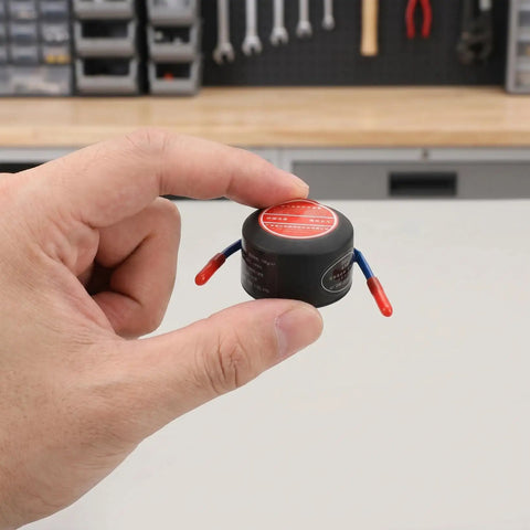Automatic Thermal Sensor Fire Extinguisher Hella Compact 10g Peel Stick Mount held in hand showcasing size and design.