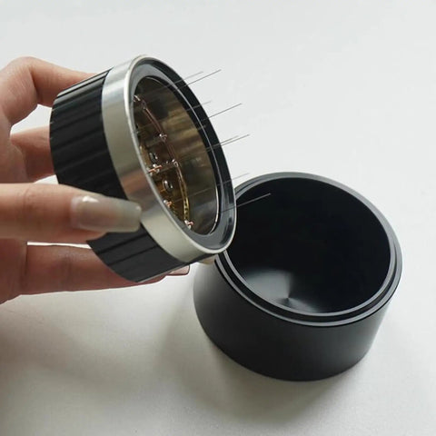 Slick 58mm Coffee Distributor Needle With Geared Spinning Action And Sturdy Black Base, showing the needle from a hand perspective.