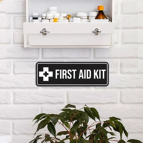 Durable Navy Blue And White First Aid Kit Sign on wall under open cabinet with medical supplies