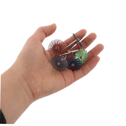 Hand holding assorted Radial Bristle Discs for 3Mm Shank Kit with colorful spiral flap wheels and abrasive materials.