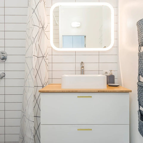 Modern bathroom vanity with rectangular mirror, white sink, and geometric shower curtain