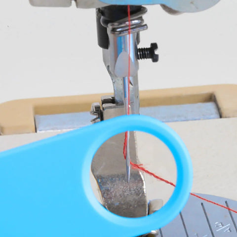 Close-up of Quick Automatic Needle Threader For Sewing Machine 3 In 1 Multitool with magnifier threading needle on sewing machine.