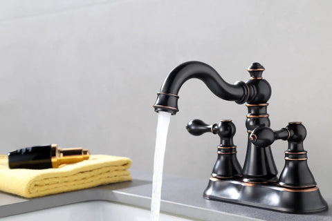Oil Rubbed Bronze Two Handle Bathroom Sink Faucet for 3-Hole 4-Inch Center Set with Pop-Up Drain in use on a sink