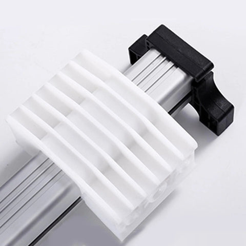 Electric linear actuator slide block; close-up view of white ribbed plastic on silver aluminum rail with black end cap