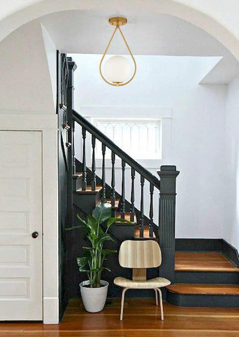 Industrial Mid Century Modern Brass Semi Flush Mount Ceiling Light With Opal Milk Glass Globe Fixture in hallway setting
