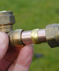 Brass compression fitting with 1/4" tube OD, ferrule sleeve on copper tube; close-up view