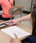 Top Shelf Chalkboard Style K-2 Desk Reference Mats, Built Tough Premium Plastic Teaching Companions For Elementary Students on a classroom desk.