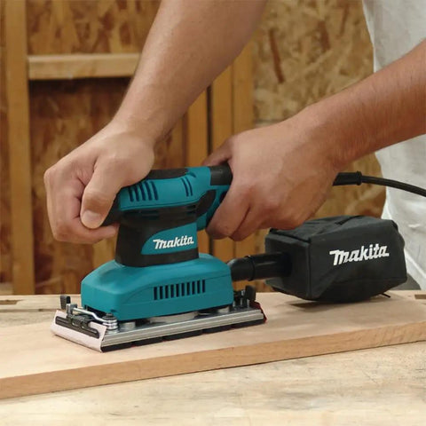 Using Beast Of A Sheet Finishing Sander One Third Inch Orbit, 1.7 Amp, Teal Finish With Ergonomic Rubberized Grip on wooden surface