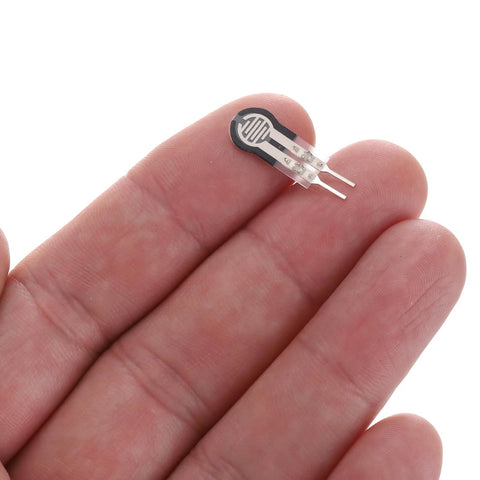 Close-up of MECCANIXITY FSR-400sB thin-film pressure sensor disk with two metal leads