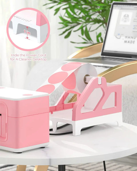 Heavy Hitter Universal Thermal Shipping Label Holder And Fan Fold Roll Organizer No Sweat Paper Dispenser Stand Pink beside printer on desk.