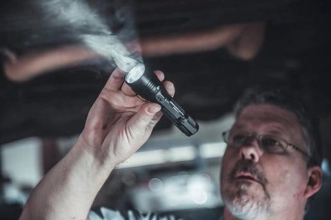 Person using HL-X 1000 Lumen Tactical LED Flashlight With Ten-Tap Programmable Power Modes under a car hood