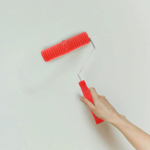 Red Grain Pattern Paint Roller For Wall Texturing With Ergonomic Plastic Handle in use against white wall.