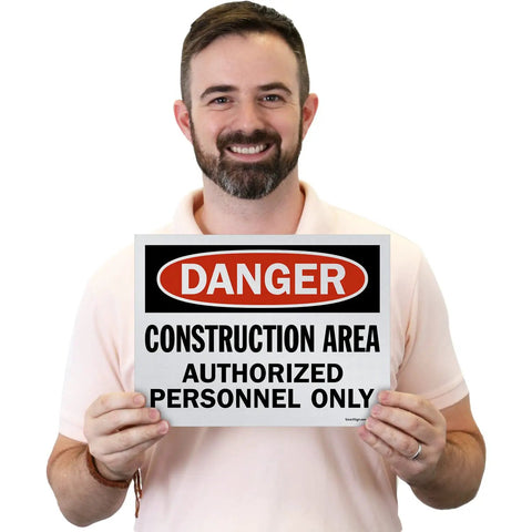 Danger Construction Area Authorized Personnel Only OSHA Sign held by a man, 9x12 inch screen printed polystyrene for tough environments.