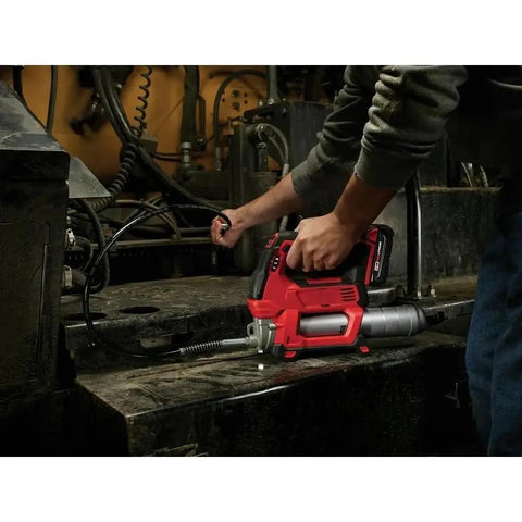 Professional Cordless Grease Gun Kit Fits Milwaukee M18 Platform used for lubrication with red finish on a workbench.