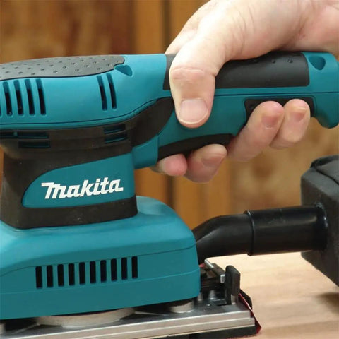 Hand holding Beast Of A Sheet Finishing Sander One Third Inch Orbit, 1.7 Amp, Teal Finish With Ergonomic Rubberized Grip, 11,000 OPM