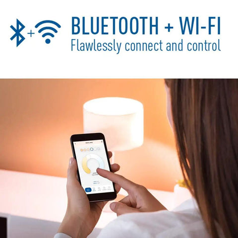 Woman using smartphone to control Smart A21 LED Bulb 100W Equivalent Tunable White To Color Changing Works With Alexa And Google Home