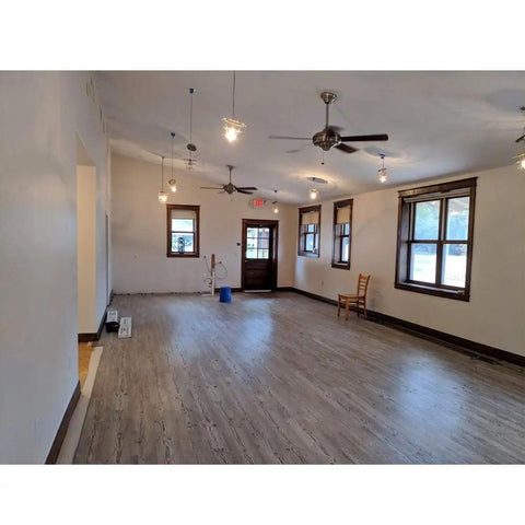 Empty room with hardwood floors and ceiling fans, potential installation site for G3 Flex 1080p Indoor Outdoor Security Cam With Night Vision And HDR.