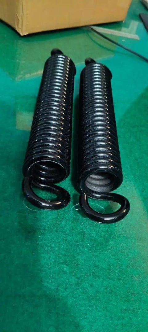 Heavy Duty Extension Springs Pair 11 Inch Hook To Hook 1.94 Inch Outer Diameter 0.33 Inch Chrome Silicon Wire Matched Set close-up on green surface.