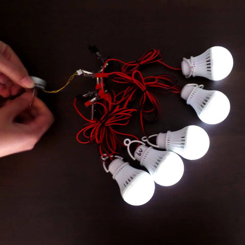Person assembling a Three Phase AC Hand Brushless Motor Generator Kit for STEM Experiments and Wind Turbine Models with light bulbs
