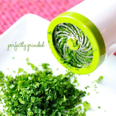 Cilantro And Spice Grinder Manual Stainless Steel Green Easy Clean Kitchen Tool grinds herbs above white surface
