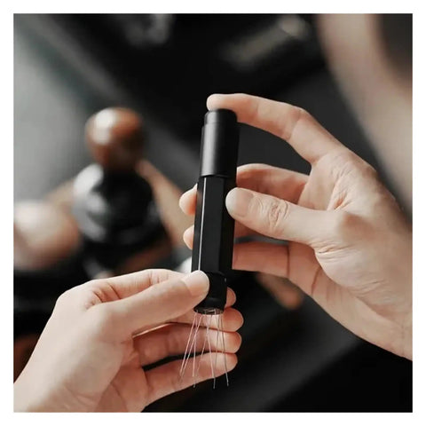 Person holding Top Shelf Telescopic WDT Tool For Espresso Distribution with stainless steel needles for barista use.