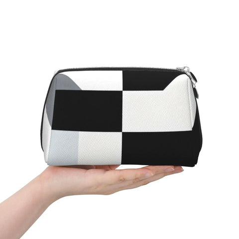 Hella Chic Black And White Piano Key Print Travel Makeup Bag in hand, durable PVC pouch for organizing brushes and skincare.