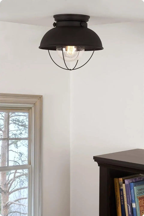 Farmhouse Nautical Flush Mount Ceiling Light With Seeded Glass Shade In Matte Black Finish installed in a room corner