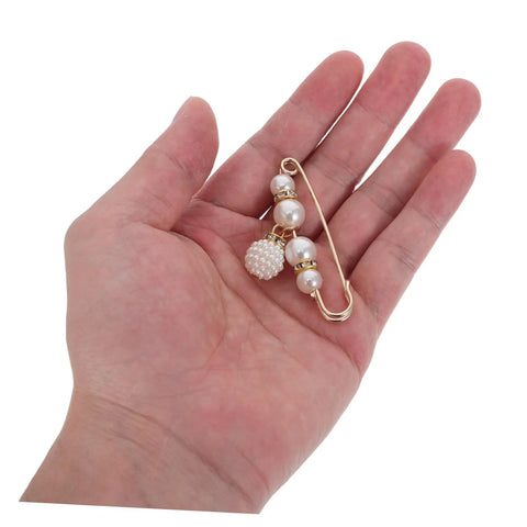 Eight Piece Pearl Waist Tightener Pin Set Elegant Alloy Dress Cincher Clips held in hand for loose trousers and gap filling.