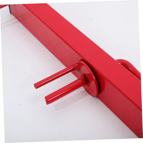Red steel manual strap winder for trucks, close-up of crank mechanism. Hand crank cargo belt winder tool, beefy steel belt tensioner.