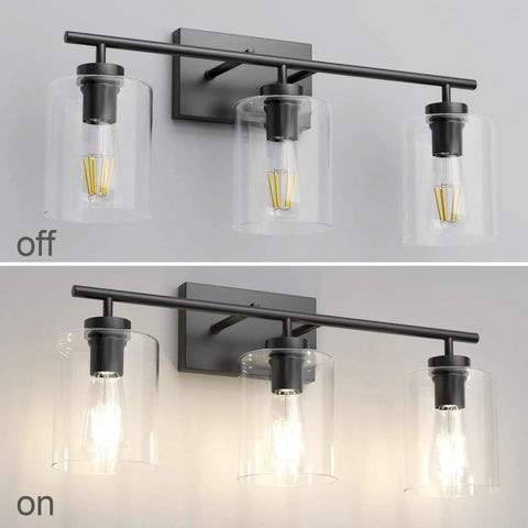 Three Light Black Vanity Light Fixture Over Mirror With Clear Glass Shades Industrial Wall Light For Bathroom Upgrade Modern Vintage Look Matte Black Frame, shown off and on.