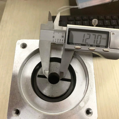 Front view of a silver NEMA 34 planetary gearbox with 1/2 in input shaft; caliper reads 12.70 mm.