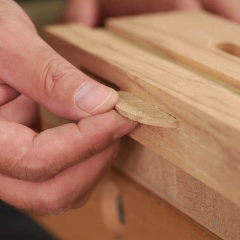 Person inserting Top Shelf Beechwood Joining Biscuit into wood joint for furniture framing.