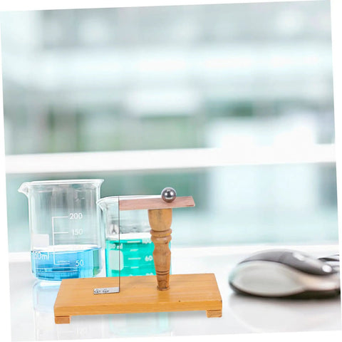 Pendulum Ball Inertia Demonstration Kit for Classroom Physics and Homeschool STEM Learning on wooden stand next to beakers