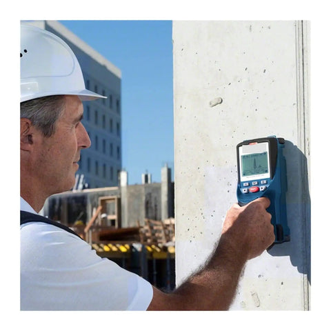 Tough As Nails Stud Finder Wall Scanner With Dead On Digital Display in use on a concrete wall by a worker wearing a hard hat.