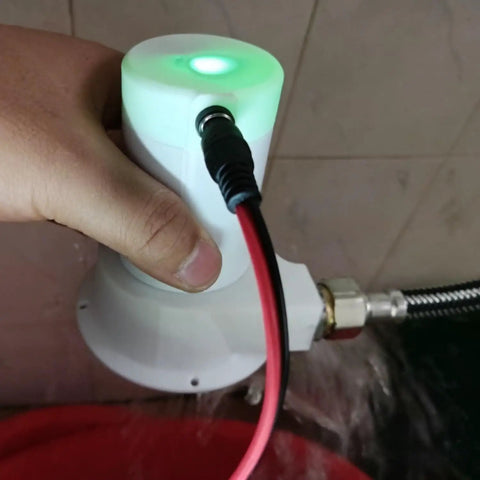 Person holding Portable 50W Micro Hydro Generator With Brushless Water Turbine in hand, connected with pipe adapter for off-grid power.