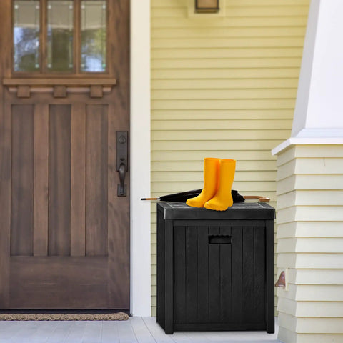 52 Gallon Outdoor Storage Box Deck Box Weatherproof Bench Black That Doubles as Extra Seating Waterproof Patio Chest Heavy Duty 440 Lb Capacity For Patio Use on a porch with yellow boots on top.