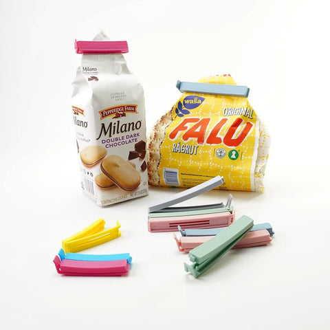 32 Piece Curved Plastic Bag Clips For Kitchen And Home Resealable Food Storage Sealers Lock In Freshness To Nuke Stale Leftovers Fast With A Rock Solid Grip That Holds Up All Week, displayed with snacks.