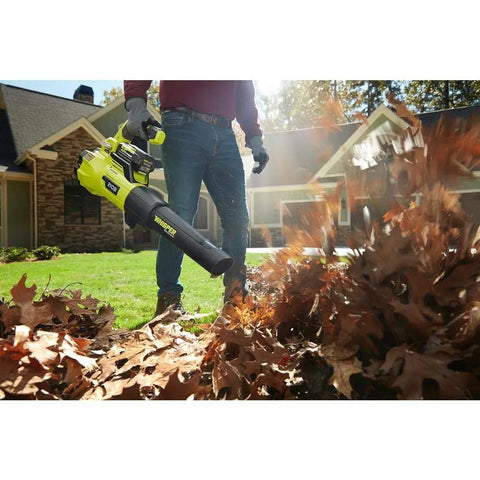A person using a Brushless Cordless Leaf Blower Packs Serious Gas Powered Punch At 125 Mph And 550 Cfm for yard cleanup.