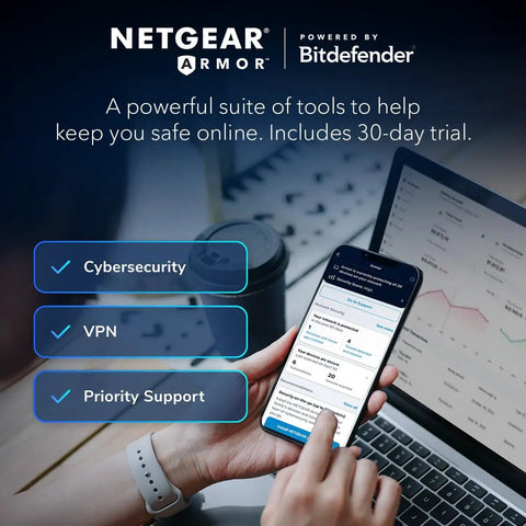 Person using a phone showing security suite features with a laptop in the background; focus on cybersecurity and VPN options.